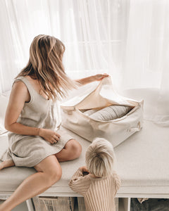 Beige organic cotton storage bag being packed by mother and child 